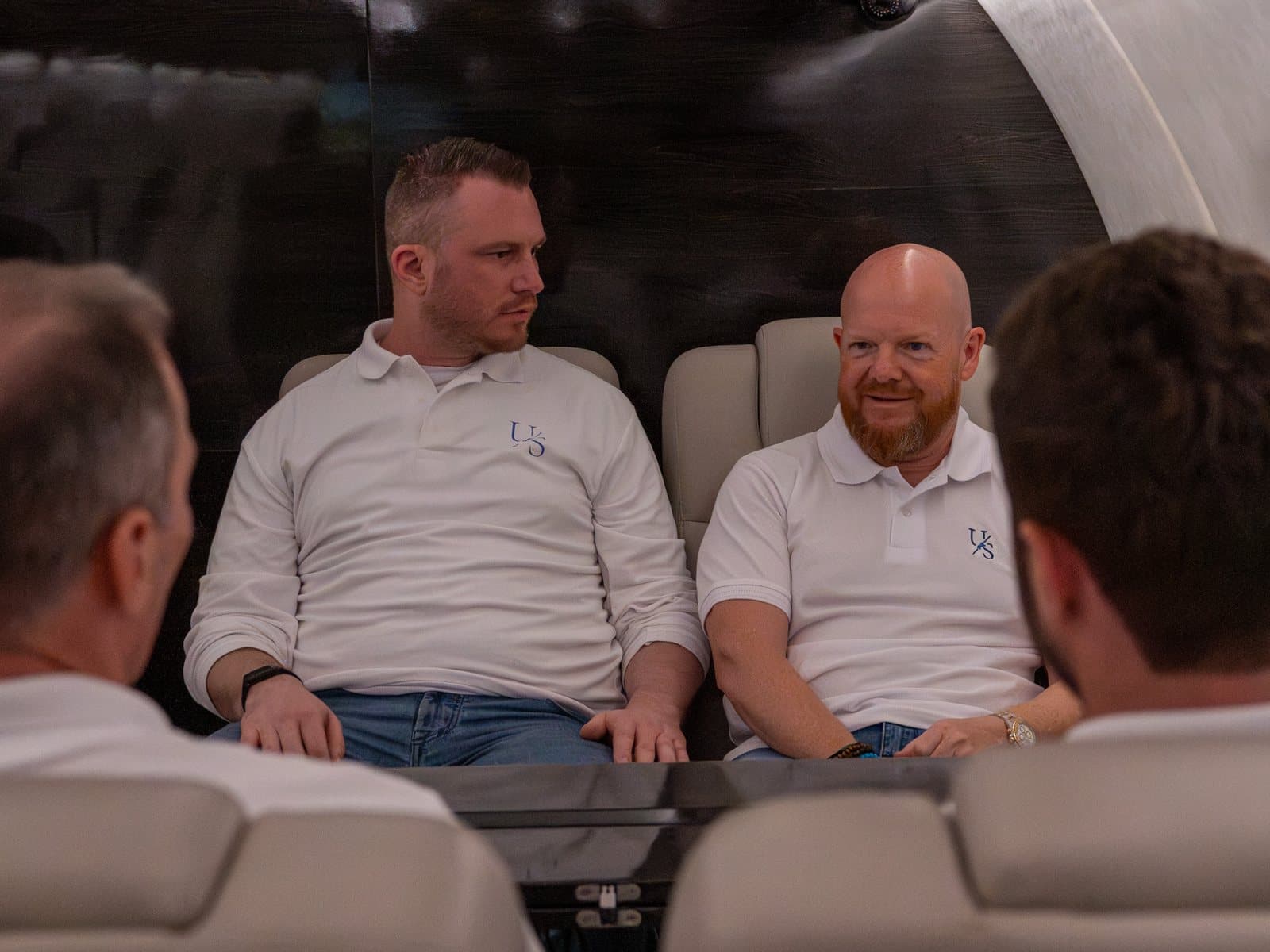 Mitglieder der Unicorn Society im Gespräch in der Kabine eines Privatjets, bei einem früheren Event