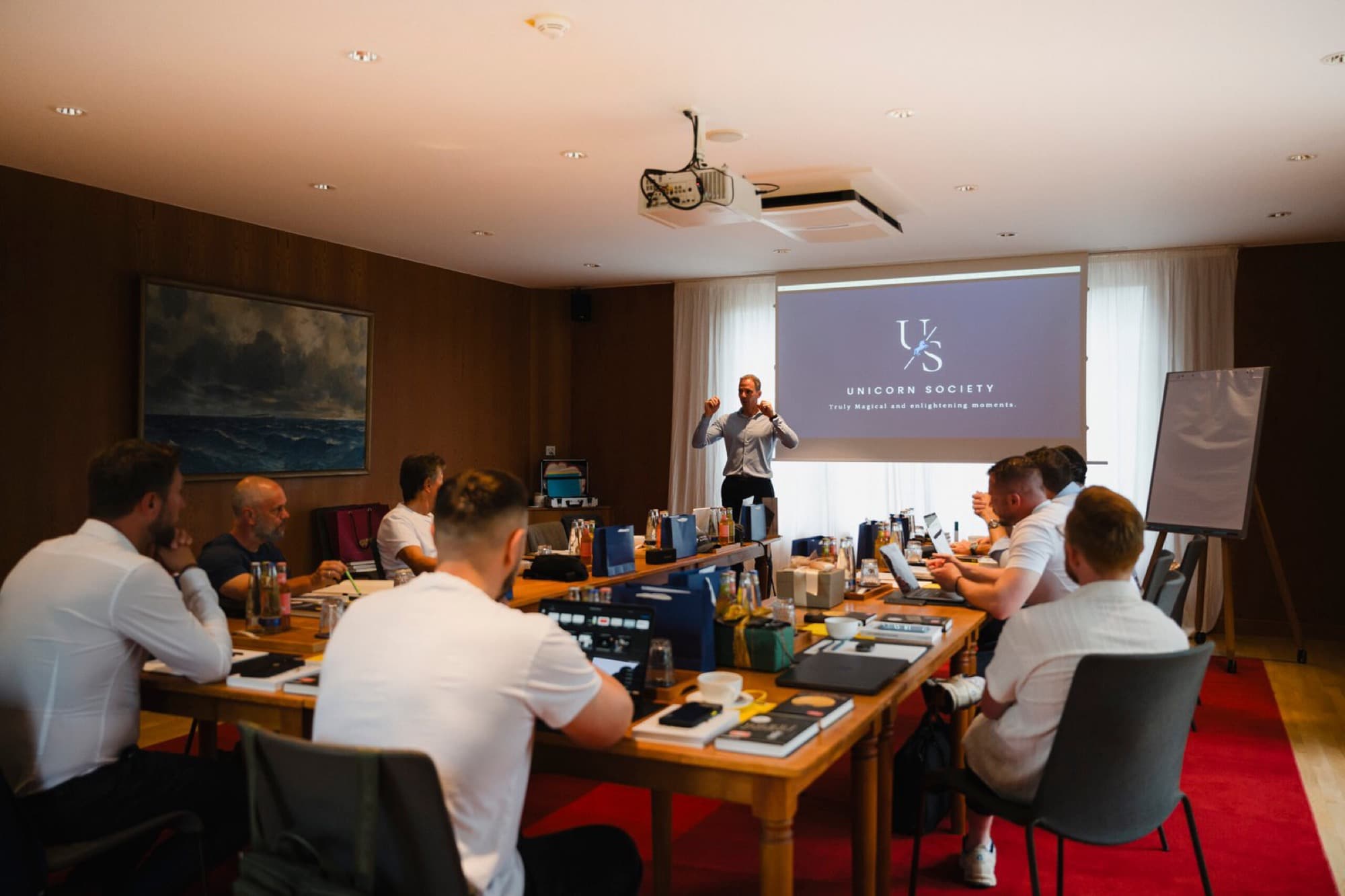 Mitglieder in einer Unicorn-Society-Session, vorne ein Referent an der Leinwand