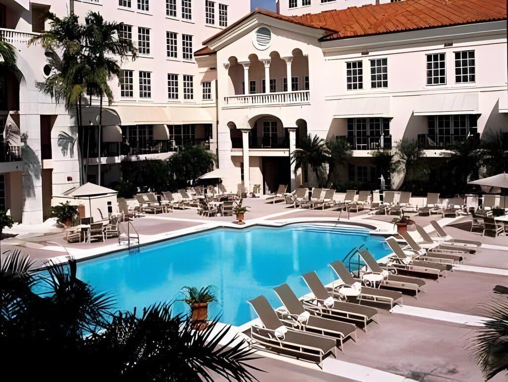 Pool mit Liegen vor dem Hotelgebäude